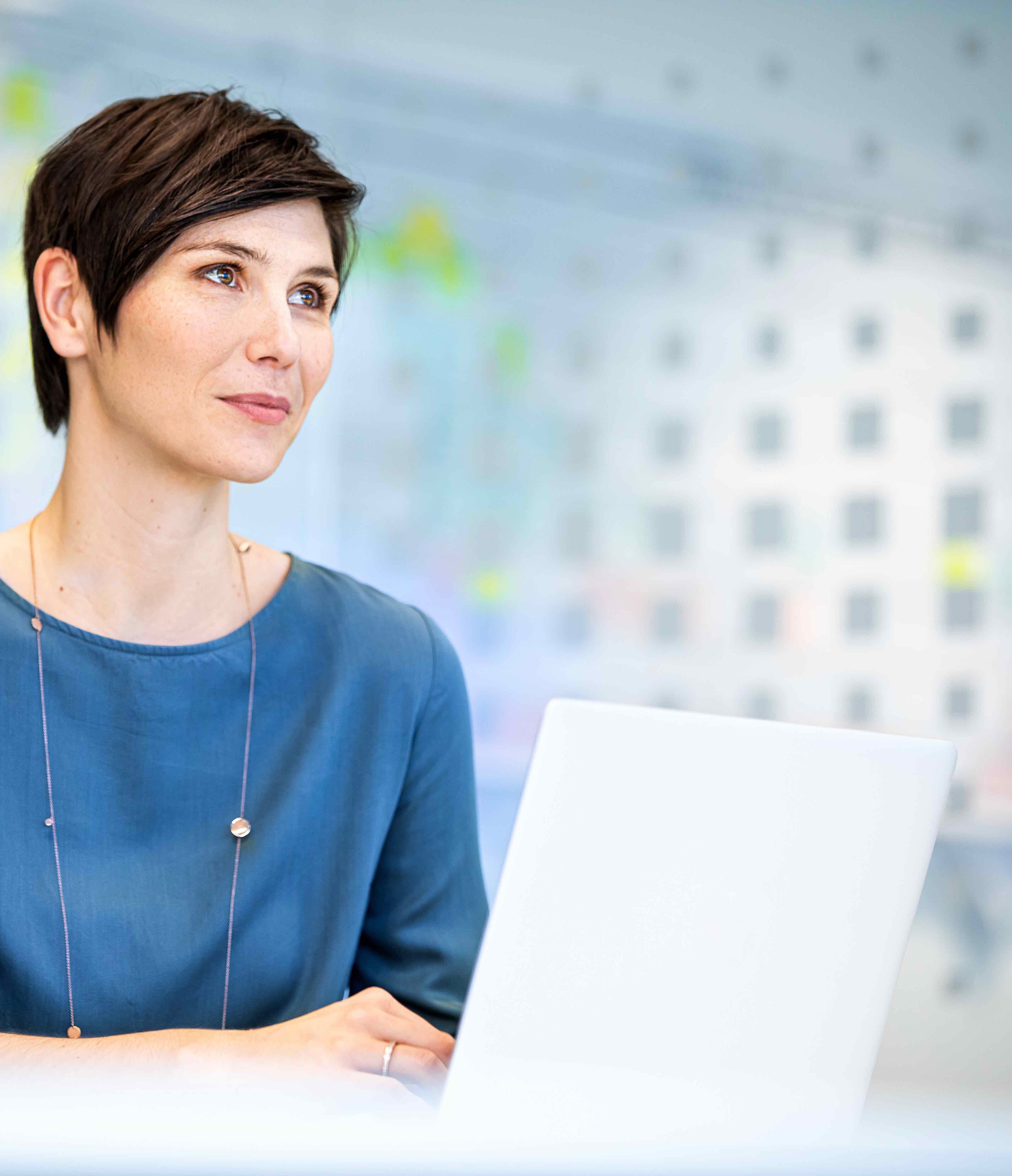 pde-Mitarbeiterin vor Laptop im Büro